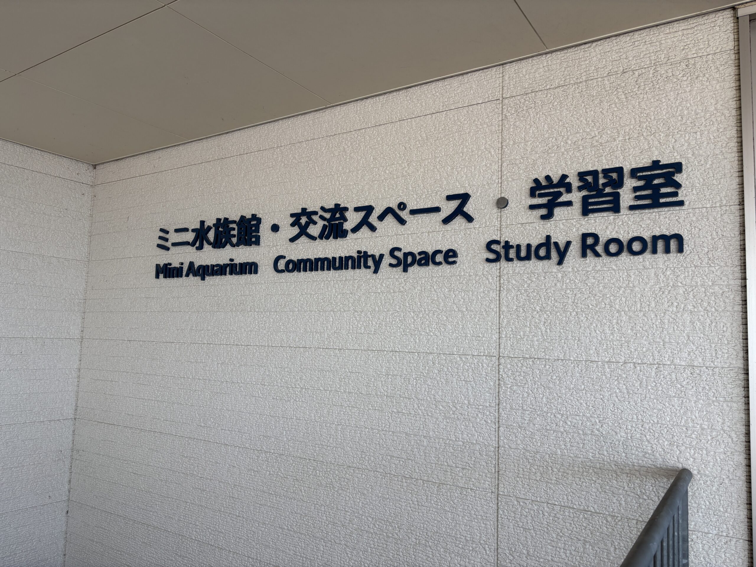 建物の外壁の看板🐠『ミニ水族館・交流スペース・学習室』とMini Aquariumの文字✨